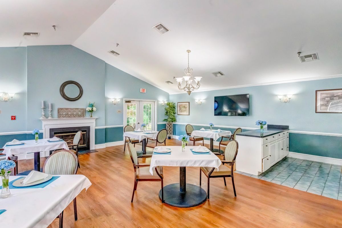 A large dining room with tables and chairs and a fireplace.