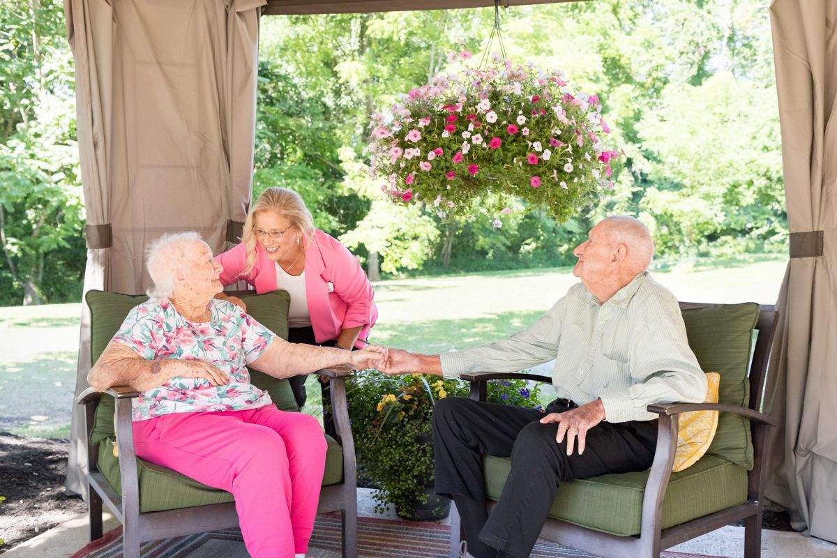 A man and a woman are sitting under a canopy holding hands.