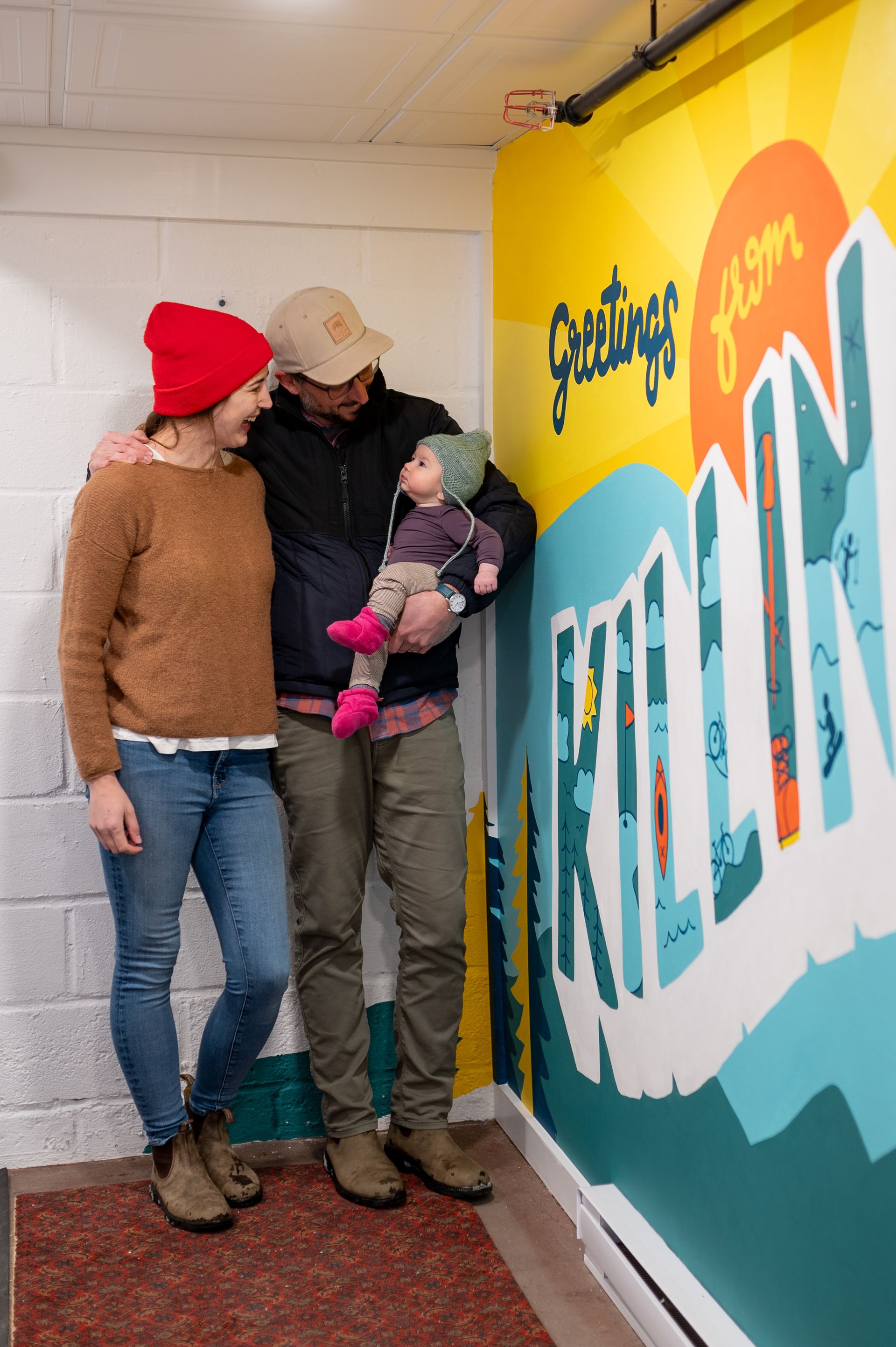 Family of three poses next to a 