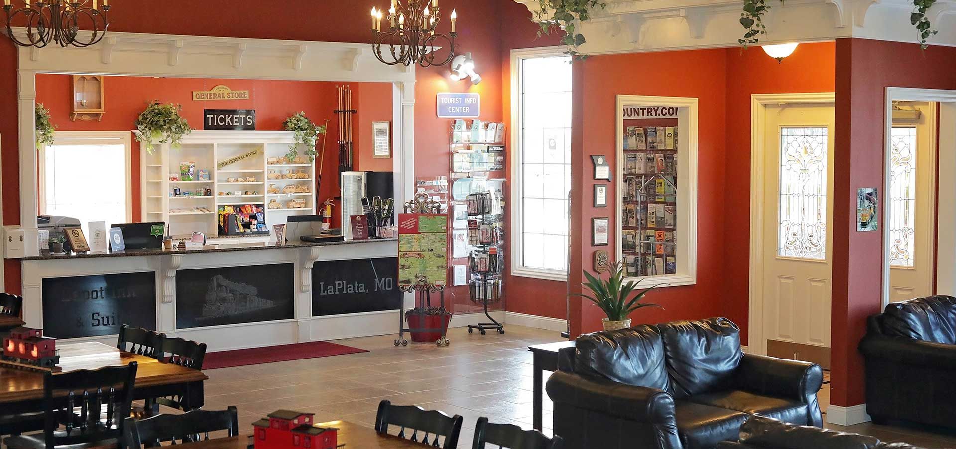 Interior of a waiting room with a reception desk, seating area, and red walls.