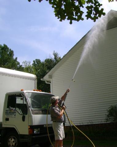 Free Estimates — Man Power Washing the Siding of House in Creedmoor, NC