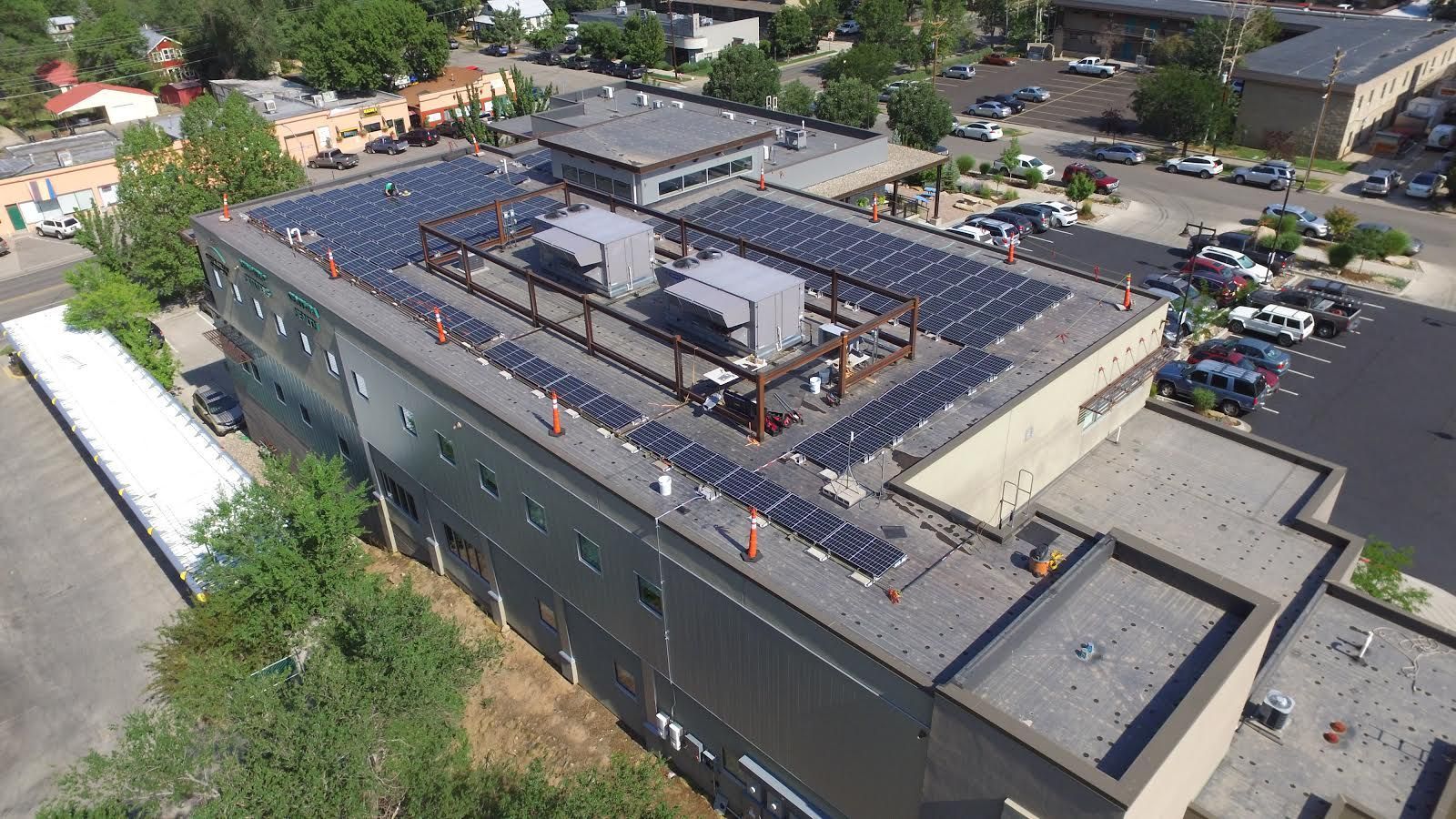 An aerial view of a building with solar panels on the roof.