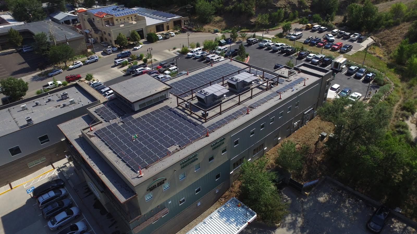 An aerial view of a building with solar panels on the roof.