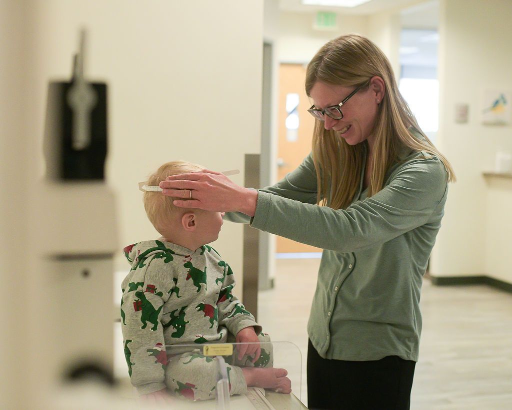 A baby is being measured for height