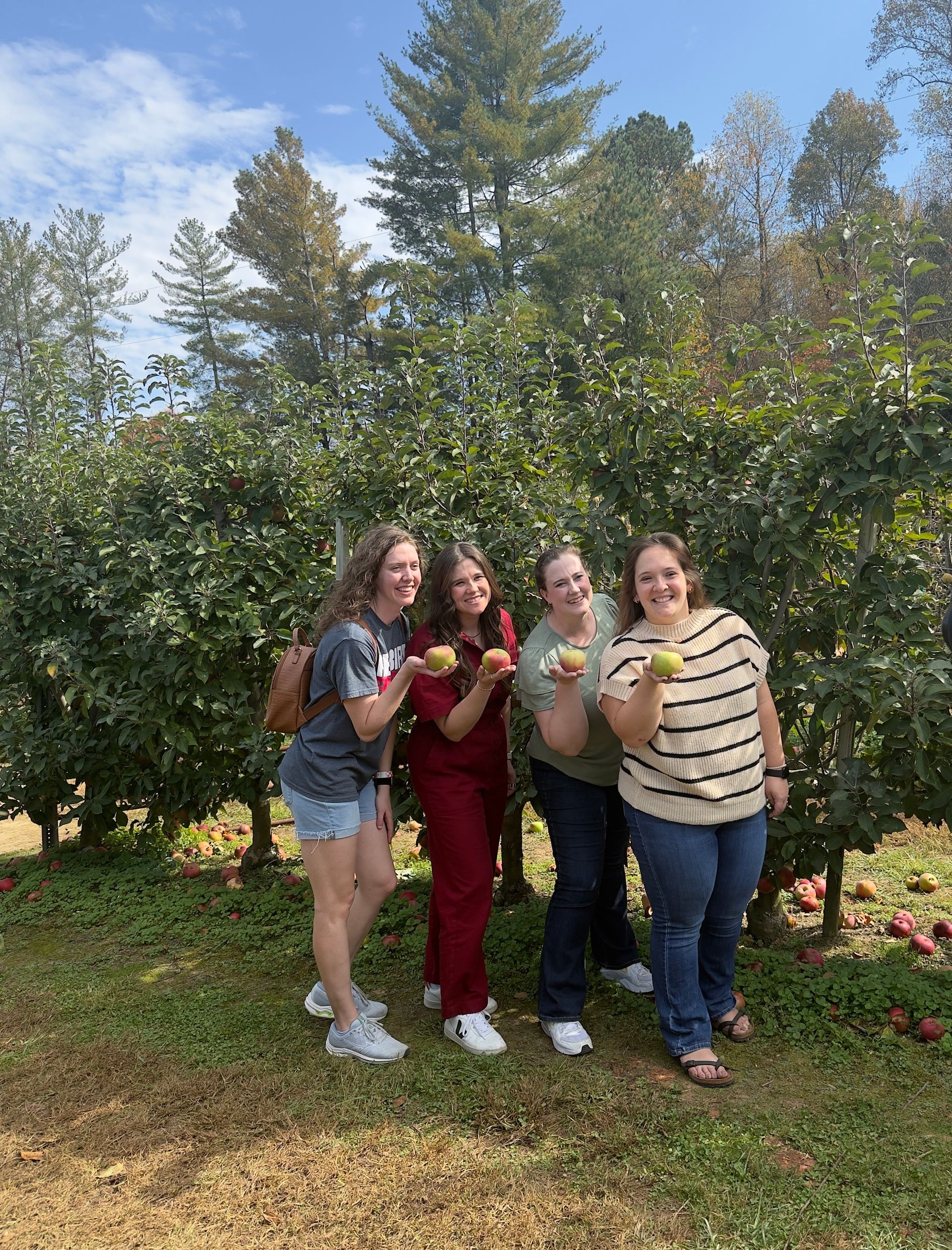 Group of students in casual attire chatting and working in a classroom setting.