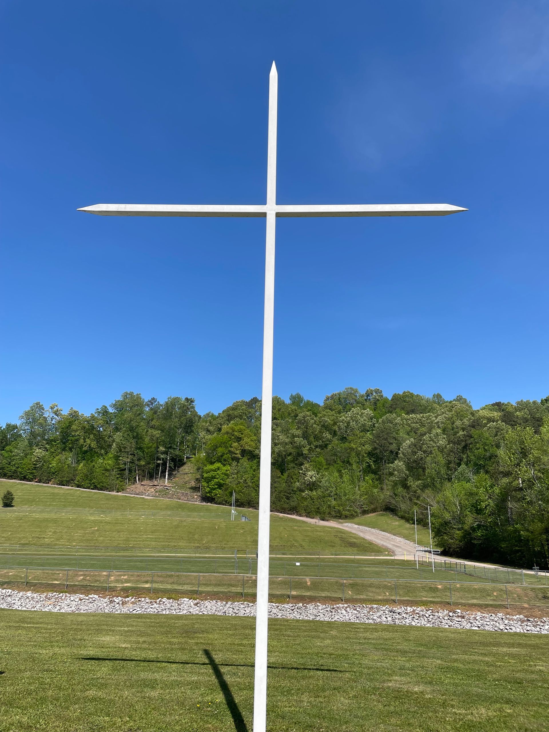 Woman with clasped hands, praying. Sunlight illuminates her face and hands, dark background.