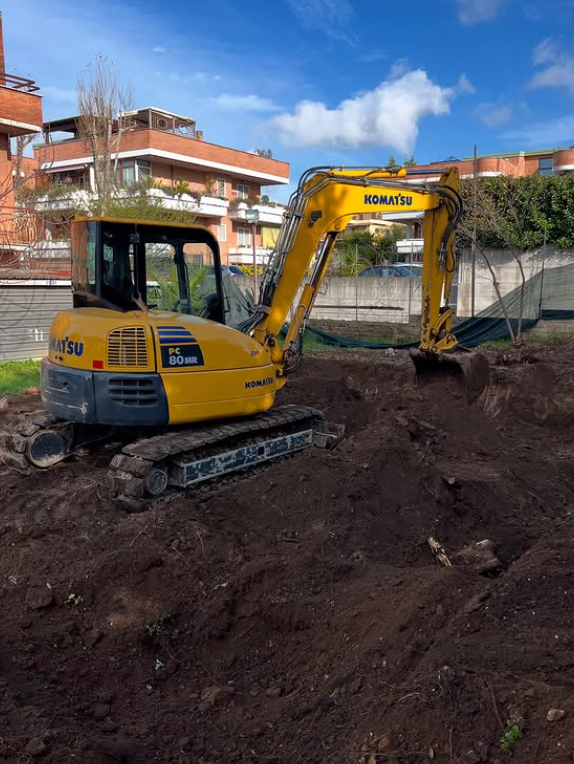 Un escavatore giallo Komatsu sta scavando nella terra