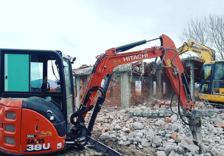 Un escavatore Hitachi viene utilizzato per demolire un edificio.