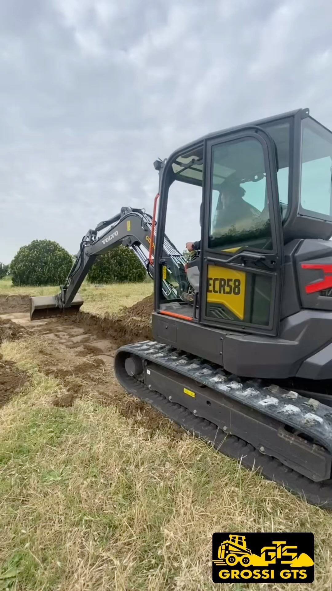 Un piccolo escavatore sta scavando una buca in un campo.