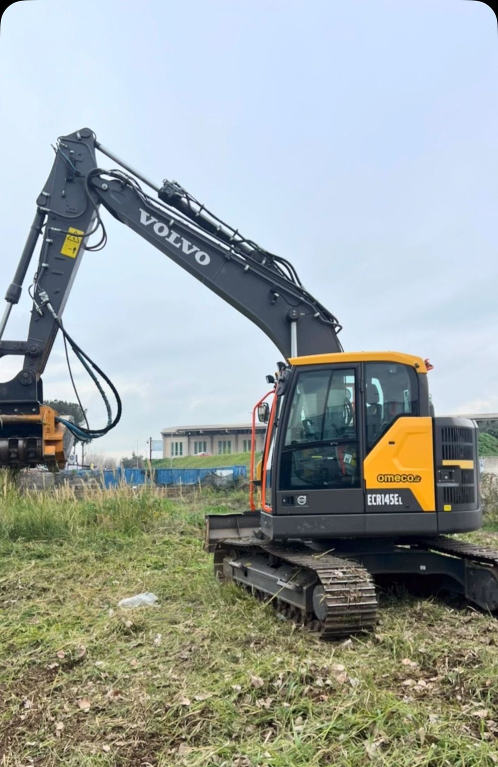 Un escavatore volvo è parcheggiato in un campo erboso.
