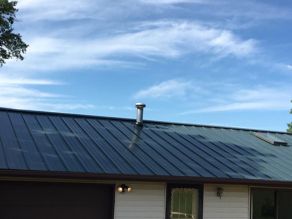 A house with a roof that has a chimney on it