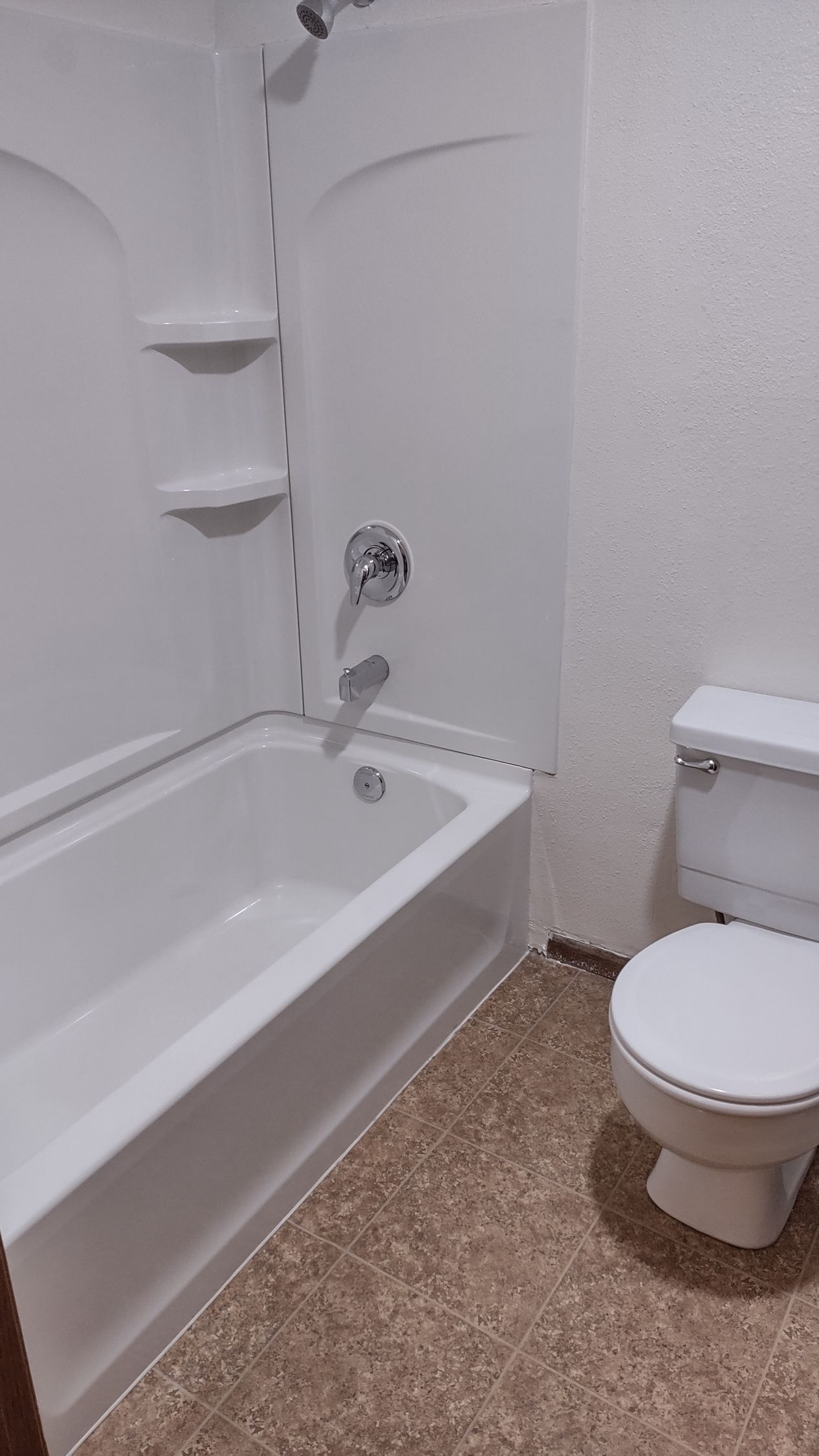 A bathroom with a tub , toilet and shower.
