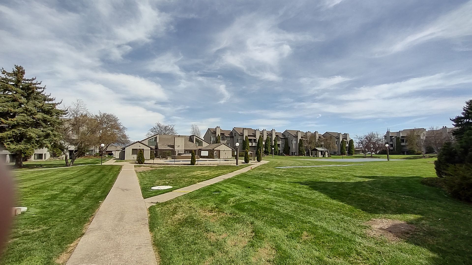 A path going through a grassy field with a building in the background.