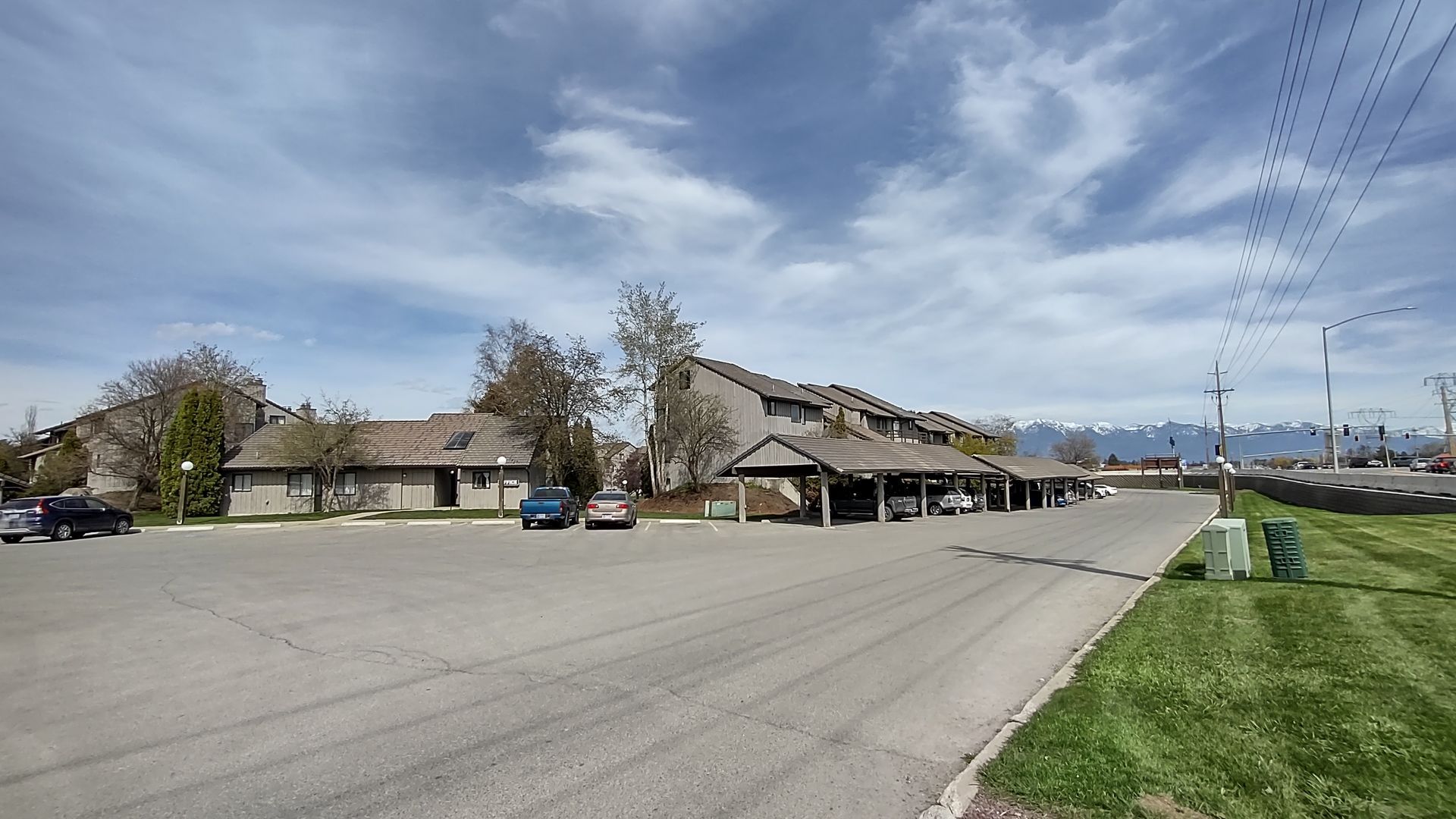 A parking lot with cars parked in front of a building.