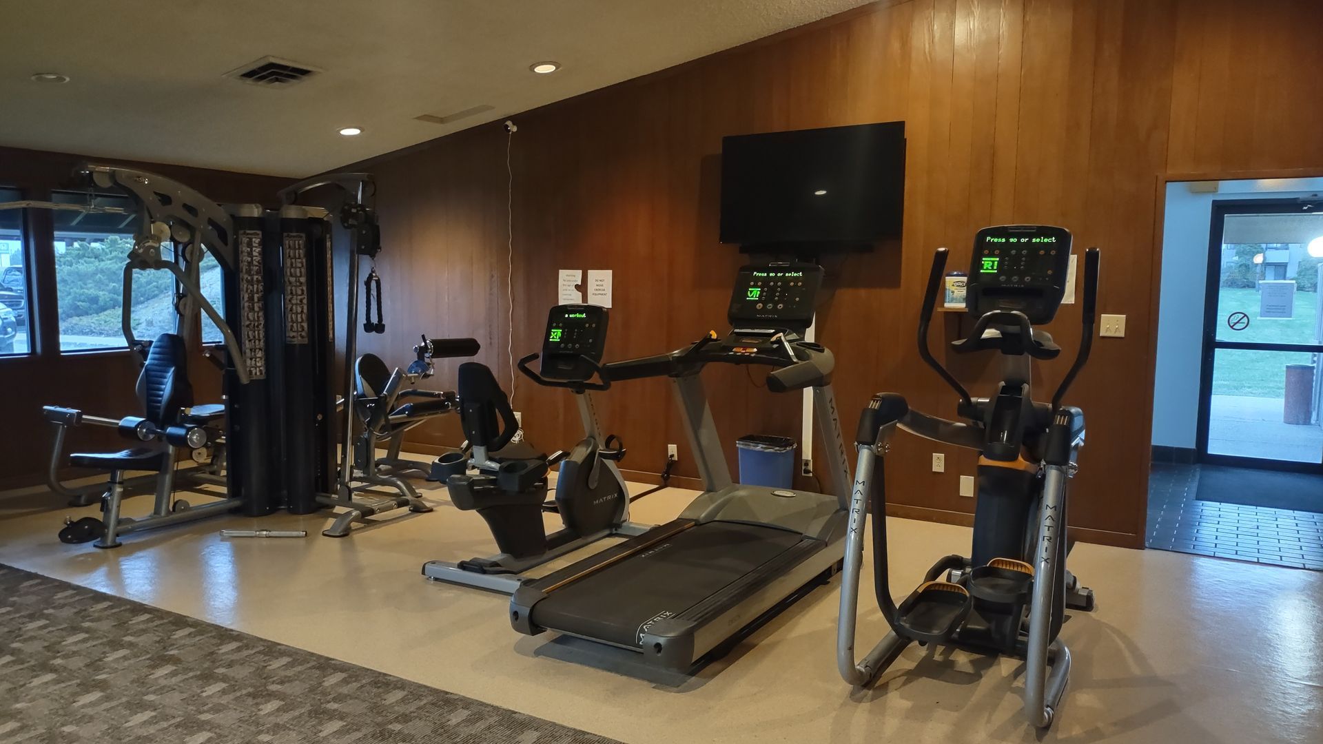 A gym with a treadmill , exercise bike , and elliptical.