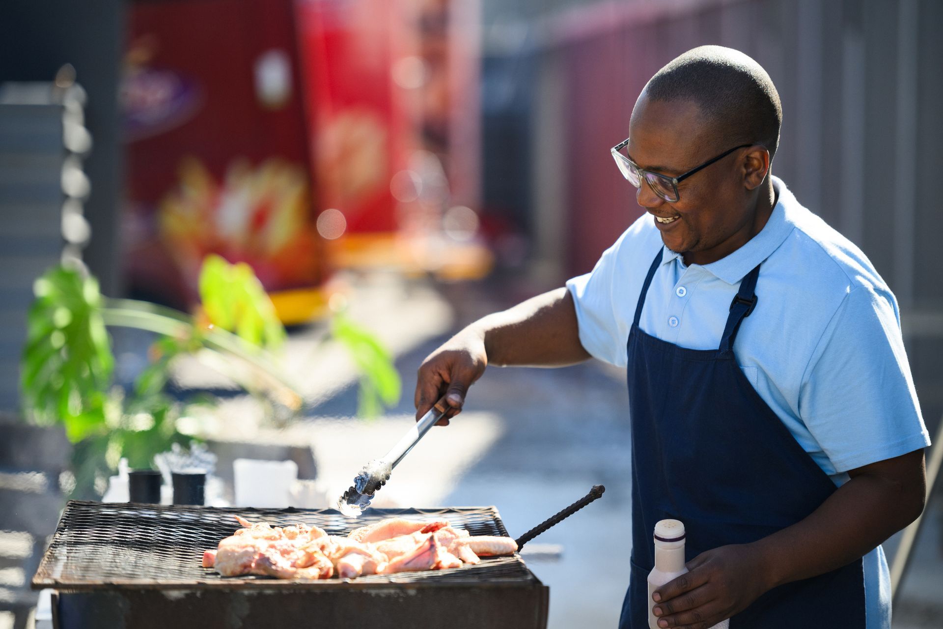 A man and a woman are cooking food on a grill.