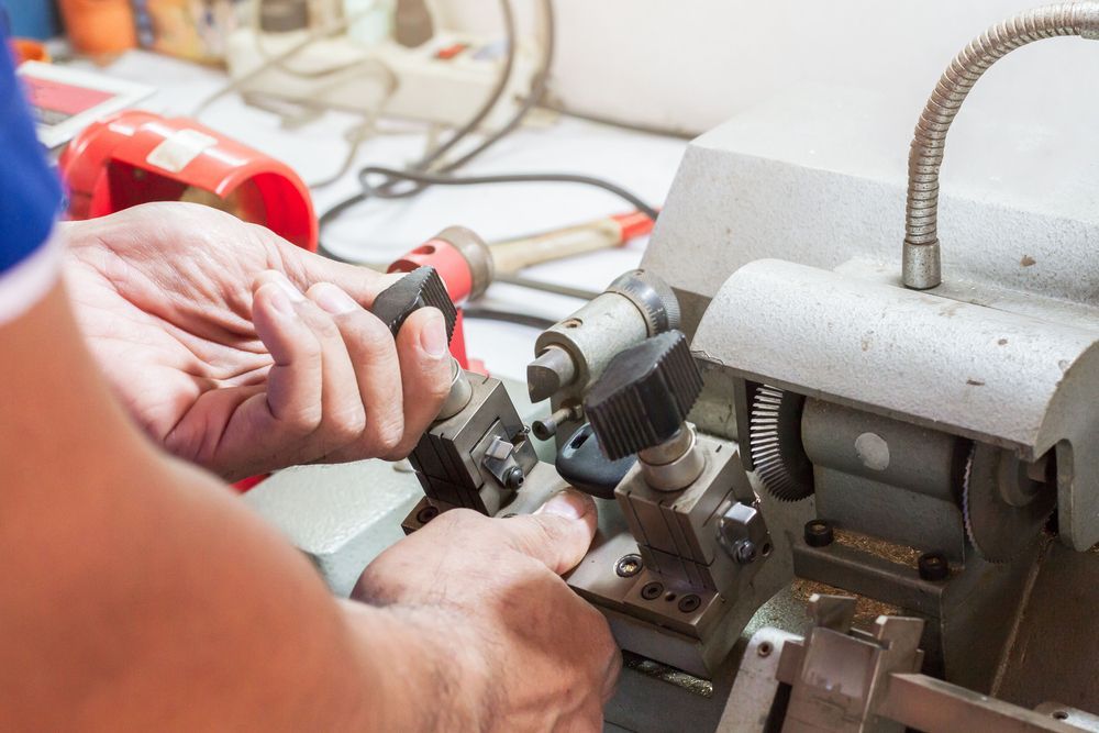 A Person Uses a Key-cutting Machine — Above and Beyond Locksmiths in Pimpama, QLD