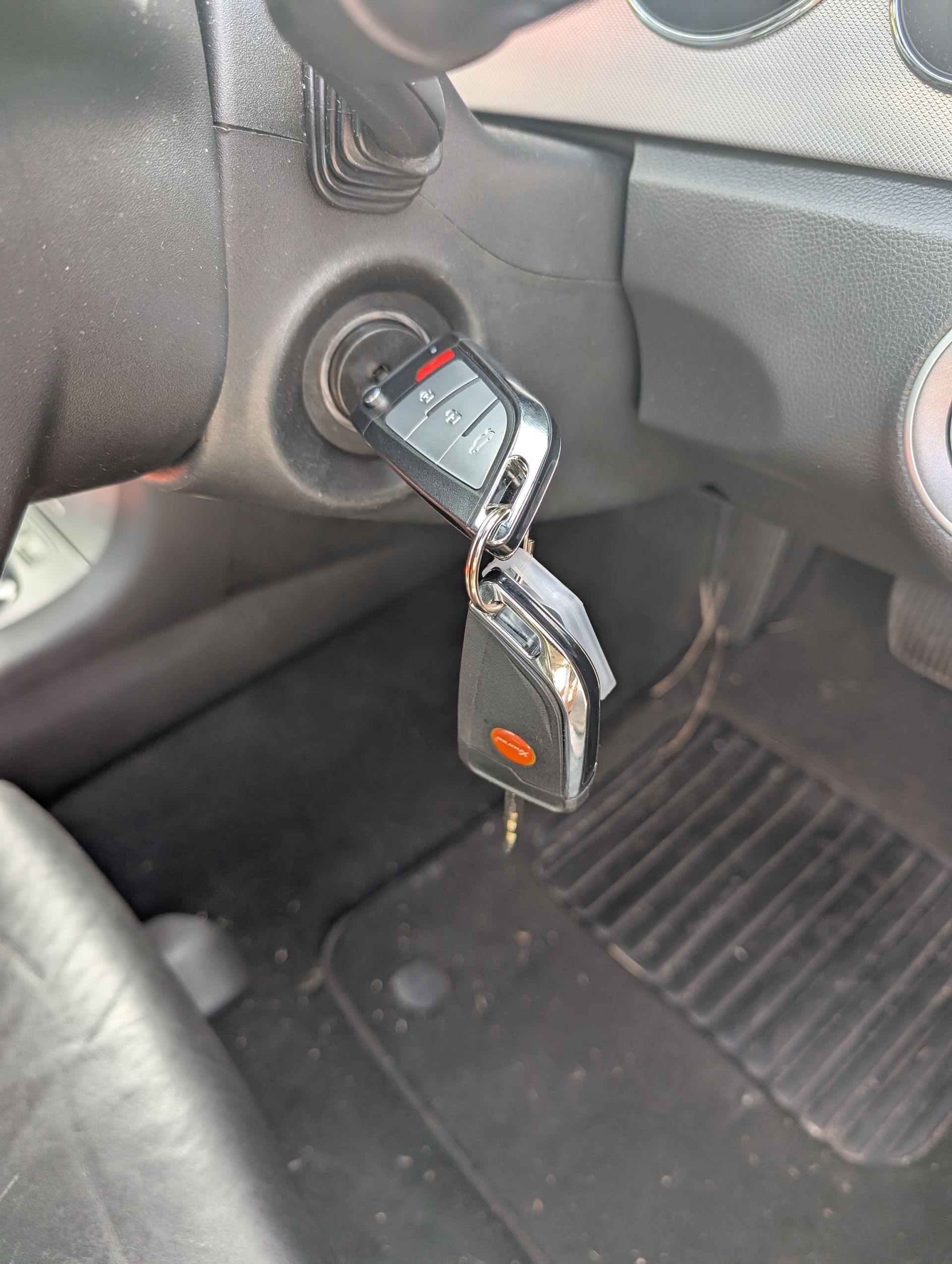 A Car Key Fob is Inserted Into the Ignition Switch — Above and Beyond Locksmiths in Coomera, QLD