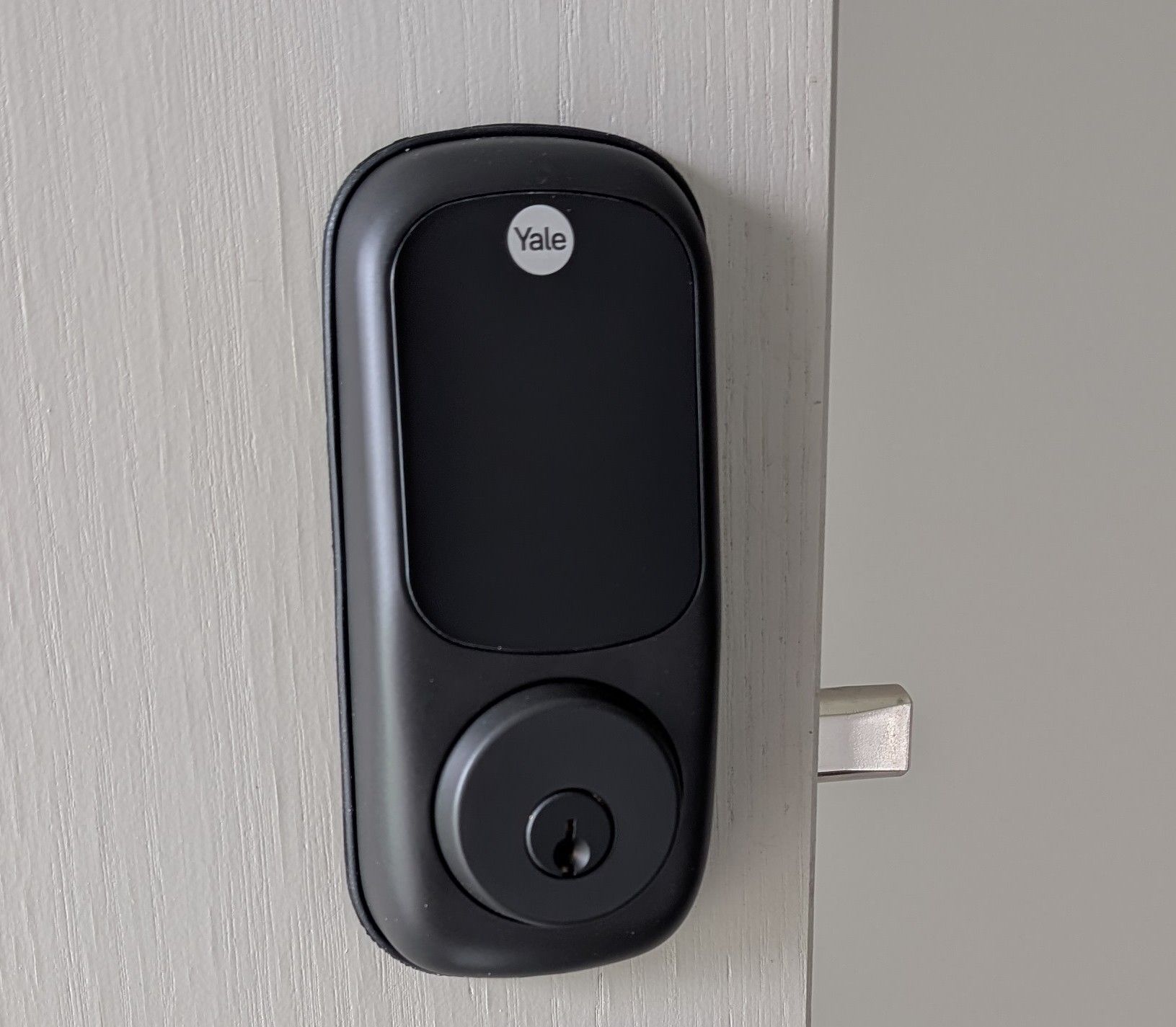 A Black Smart Lock Mounted on a Light Gray Door — Above and Beyond Locksmiths in Coomera, QLD