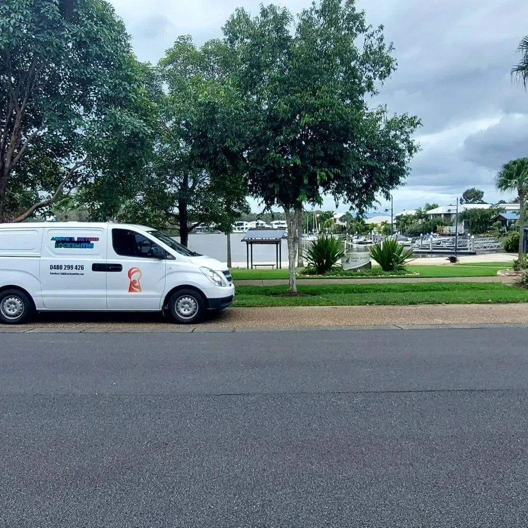 A White Work Van Parked on the Side of a Road — Above and Beyond Locksmiths in Pimpama, QLD
