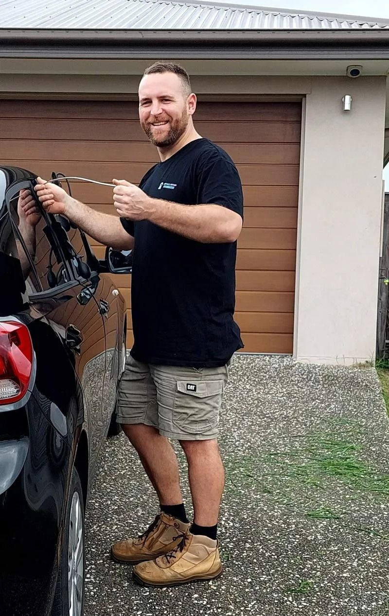 A Smiling Person in a Black T-shirt and Khaki Shorts — Above and Beyond Locksmiths in Pimpama, QLD