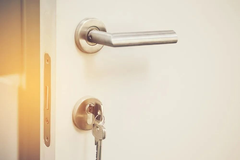 A Silver Door Handle and a Key Inserted — Above and Beyond Locksmiths in Hope Island, QLD