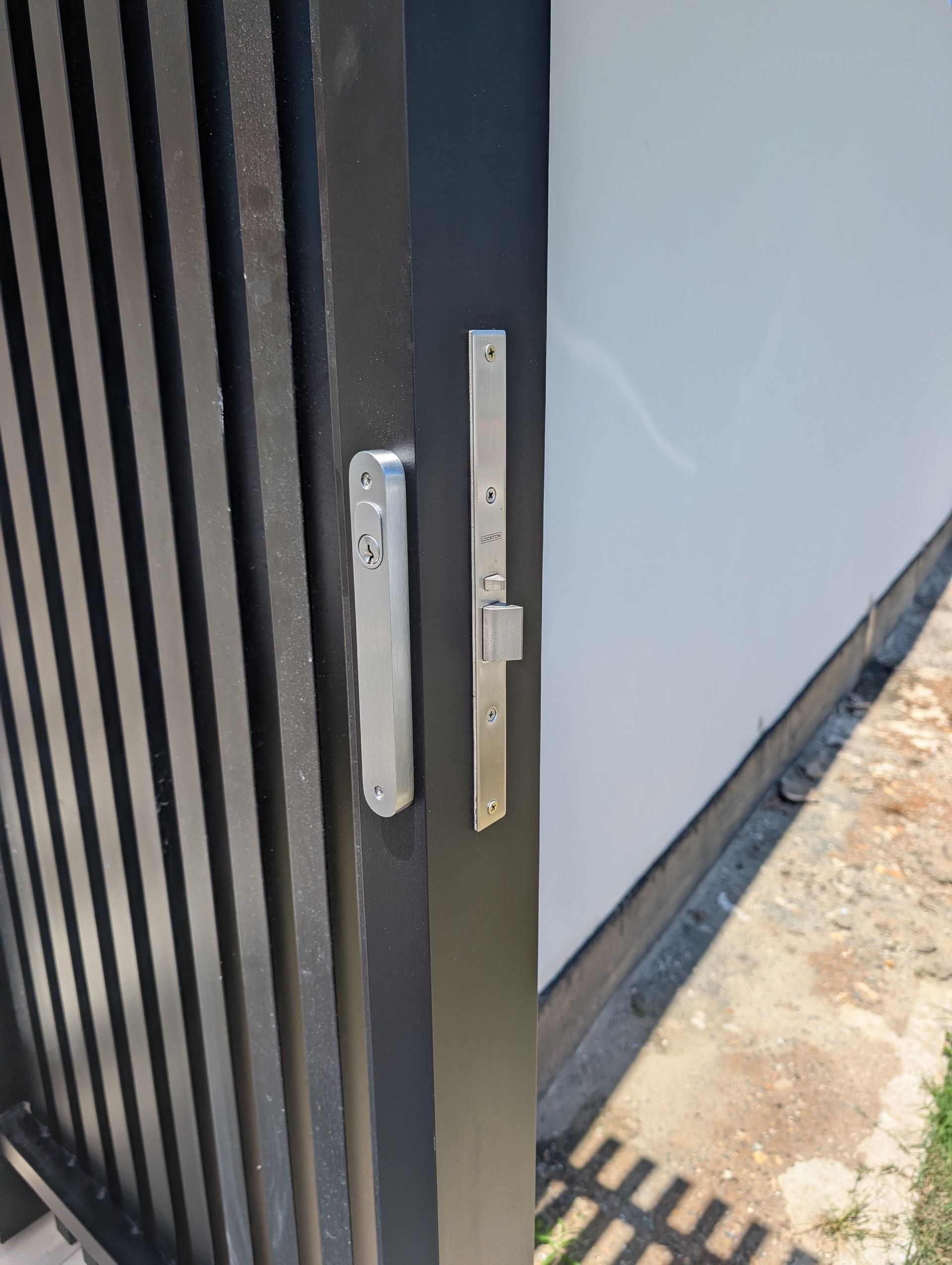 A Close-up of a Metal Sliding Gate Latch Mechanism — Above and Beyond Locksmiths in Pimpama, QLD