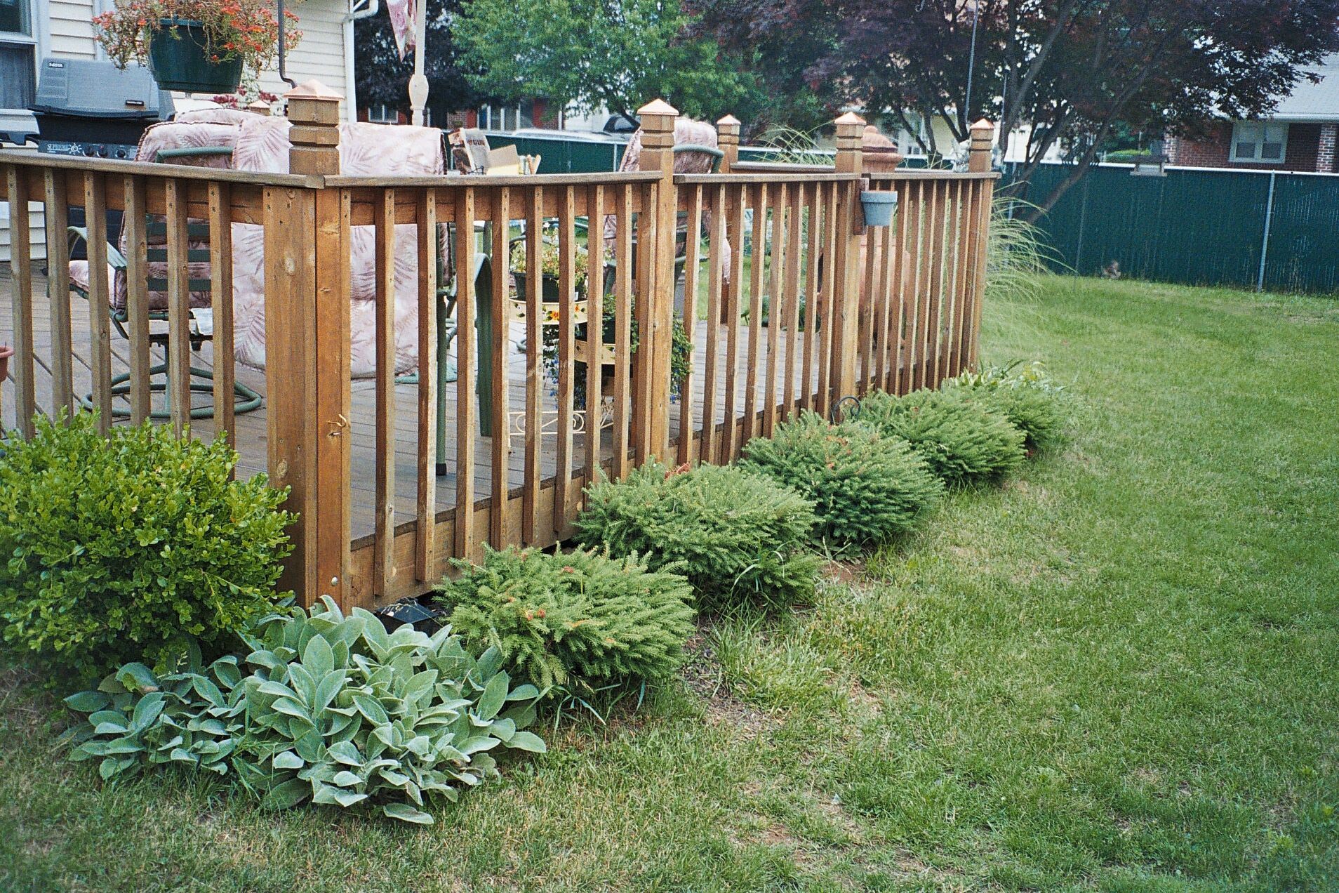 A wooden fence surrounds a lush green yard