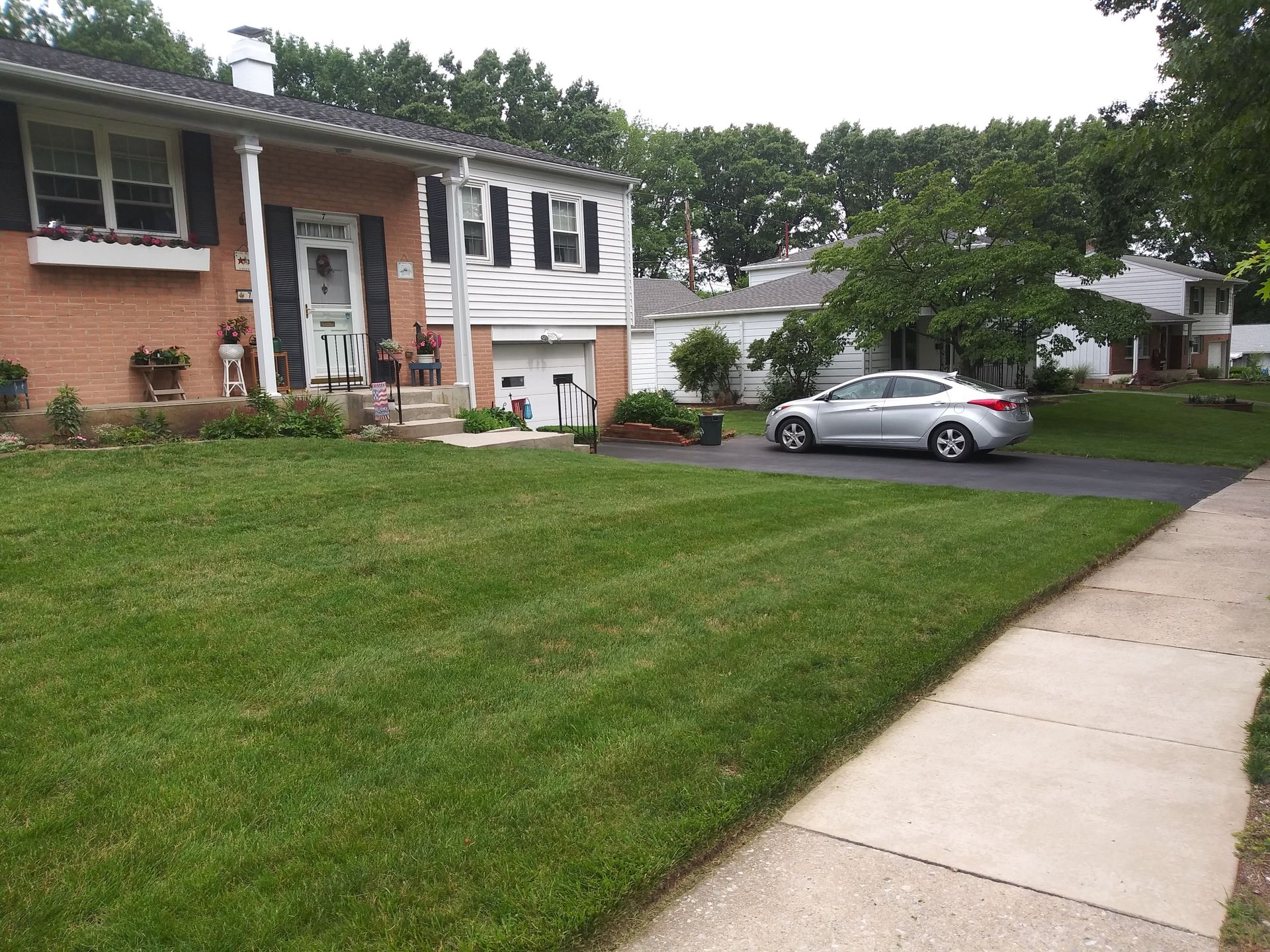 A car is parked in front of a brick house
