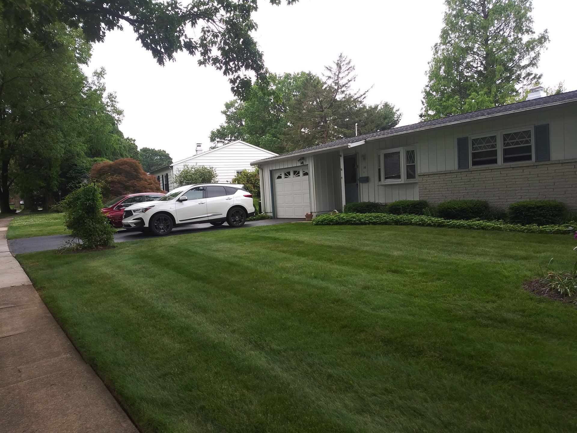 A white suv is parked in front of a white house