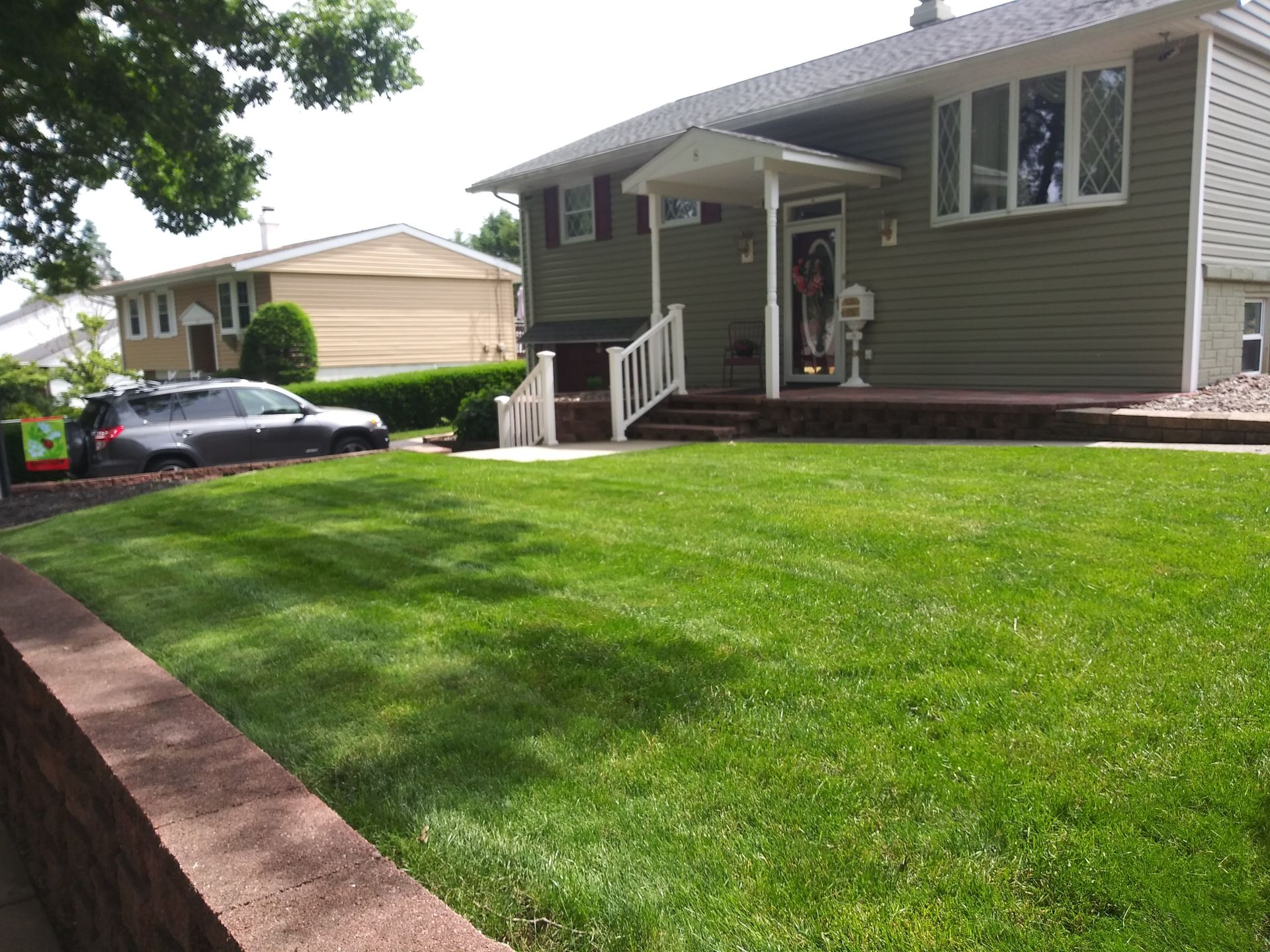 A house with a lush green lawn in front of it