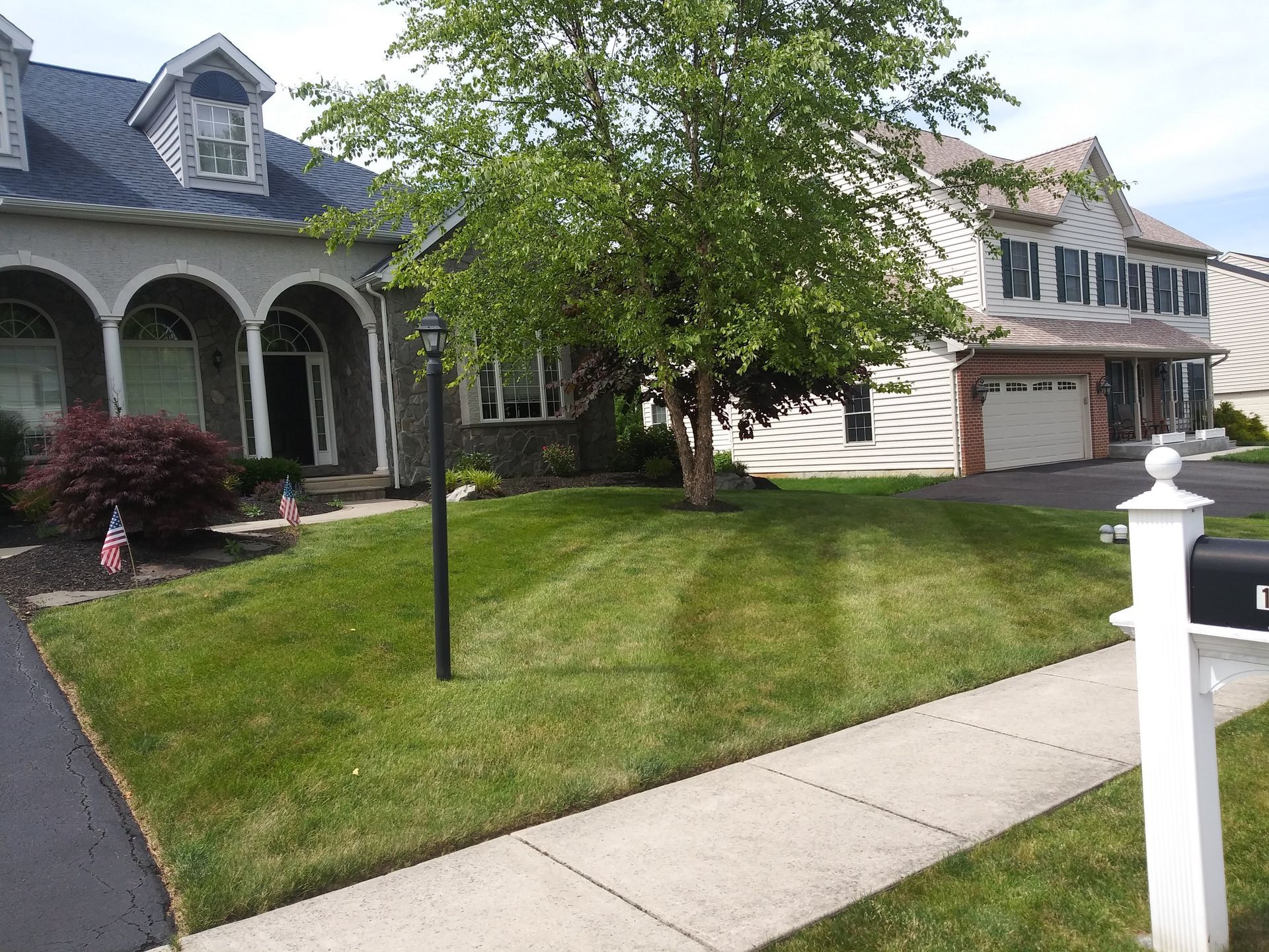 A house with a lush green lawn and a mailbox in front of it.