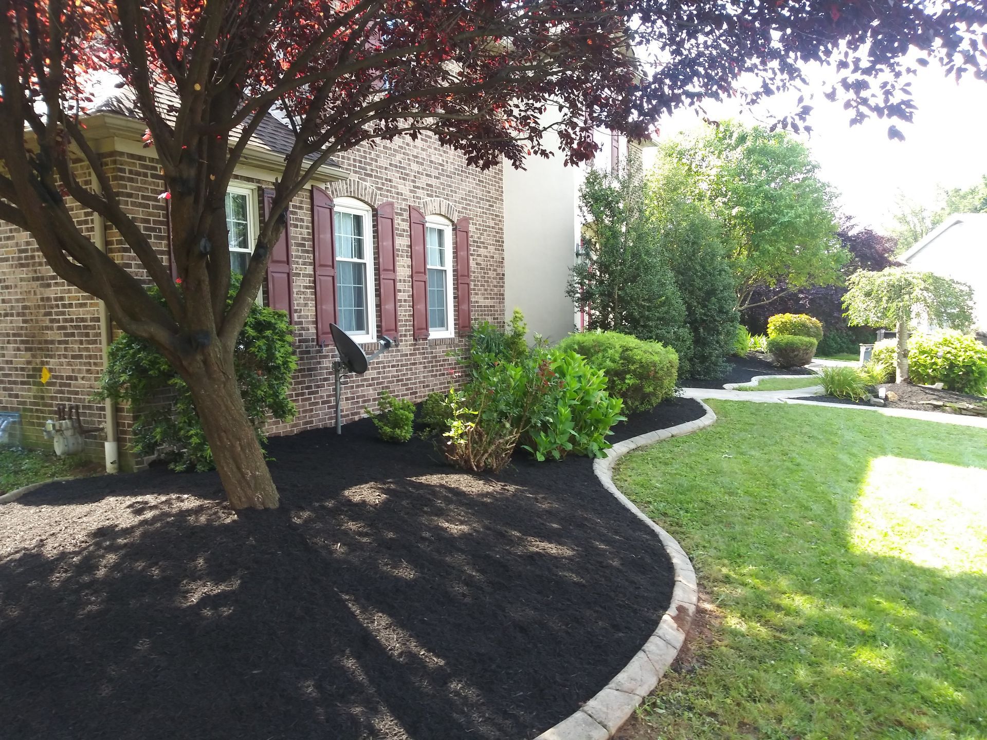 A brick house with a tree in front of it