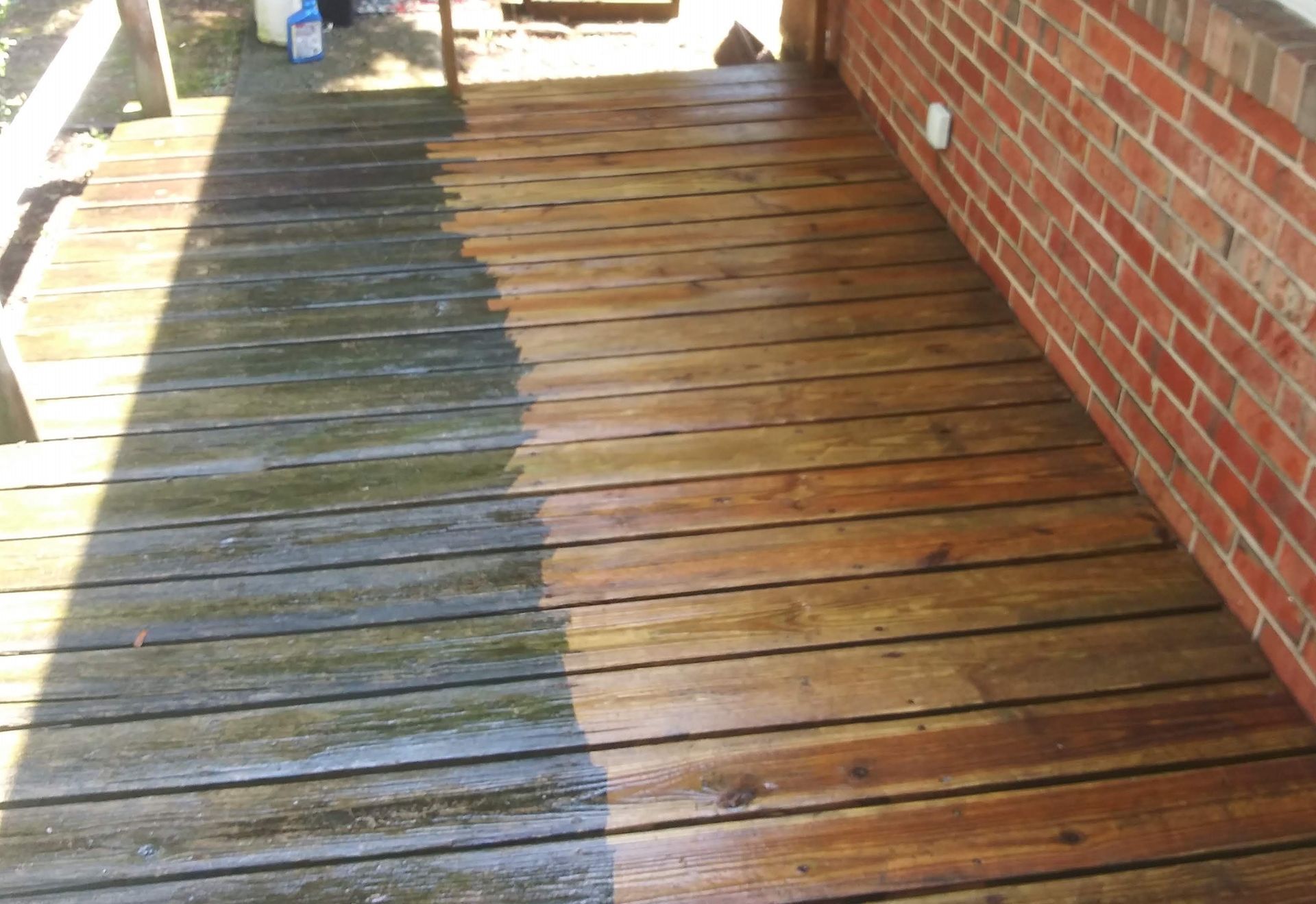 A before and after picture of a wooden deck with a brick wall in the background.
