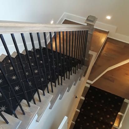 A staircase with a black carpet and a black railing.