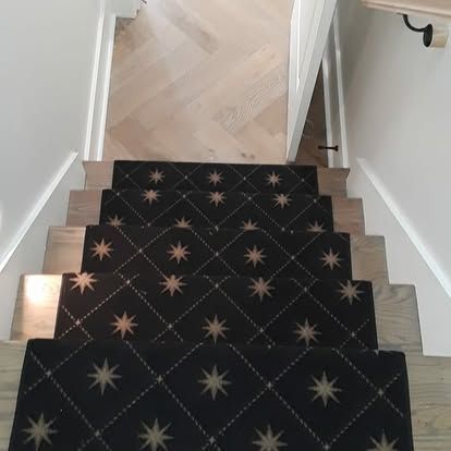 A staircase with a black carpet with stars on it