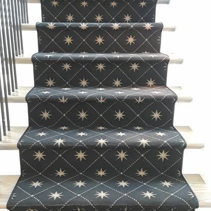 A staircase with a black carpet and white stars on it.