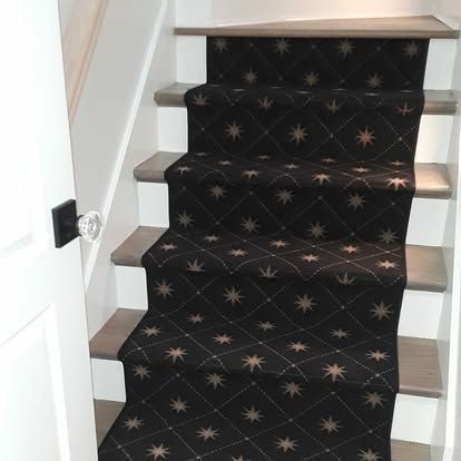 A set of stairs with a black carpet and stars on them.