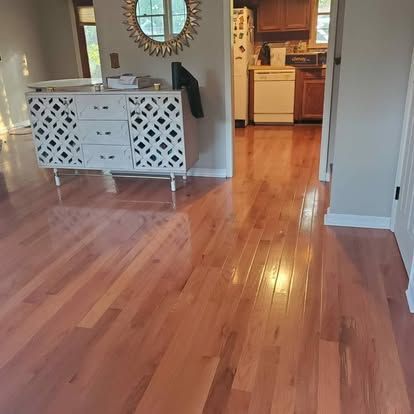 A living room with hardwood floors and a dresser.
