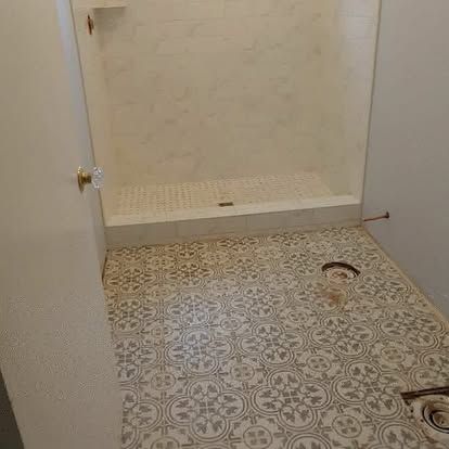 A bathroom with a shower and a tiled floor.