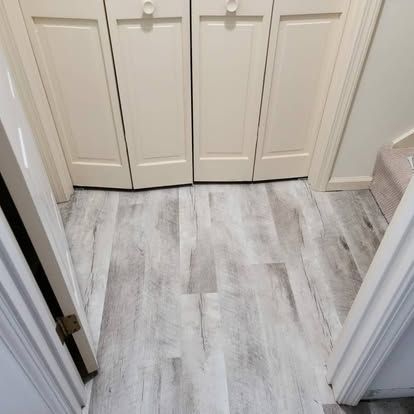 A bathroom with a gray floor and white cabinets.