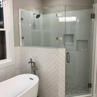 A bathroom with a bathtub and a shower with a glass door.