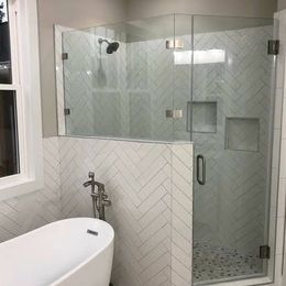 A bathroom with a bathtub and a shower with a glass door.