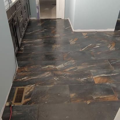 A kitchen with a tiled floor and a vent.