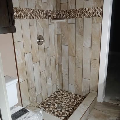 A bathroom with a walk in shower and a toilet.