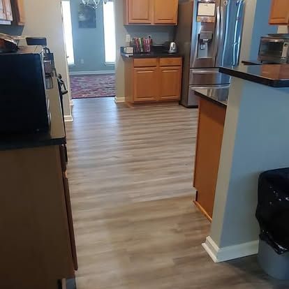 A kitchen with hardwood floors and stainless steel appliances.