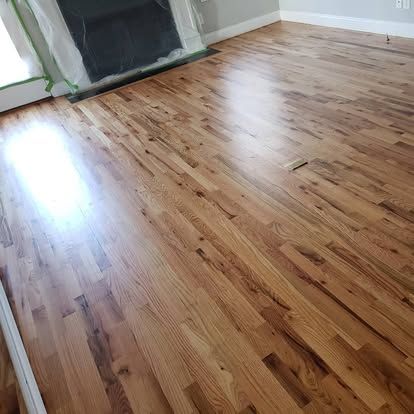 A living room with hardwood floors and a fireplace.