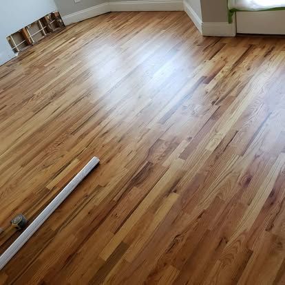 A wooden floor in a living room with a white stick on it.
