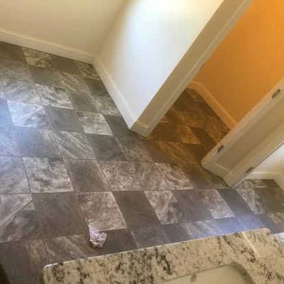 A bathroom with a tiled floor and a sink.