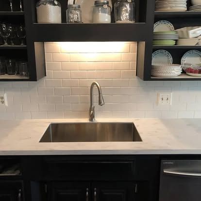 A kitchen with a stainless steel sink and a dishwasher